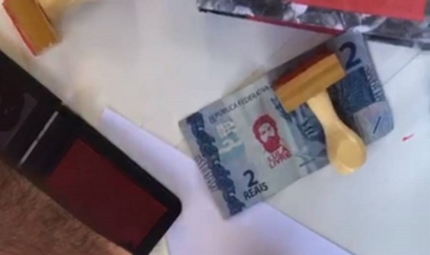 Imagem Manifestantes carimbam dinheiro com rosto de Lula