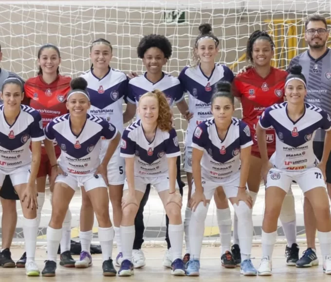 Equipe de jogadoras e comissão técnica do Cianorte Futsal Feminino posando para foto oficial dentro da quadra do ginásio