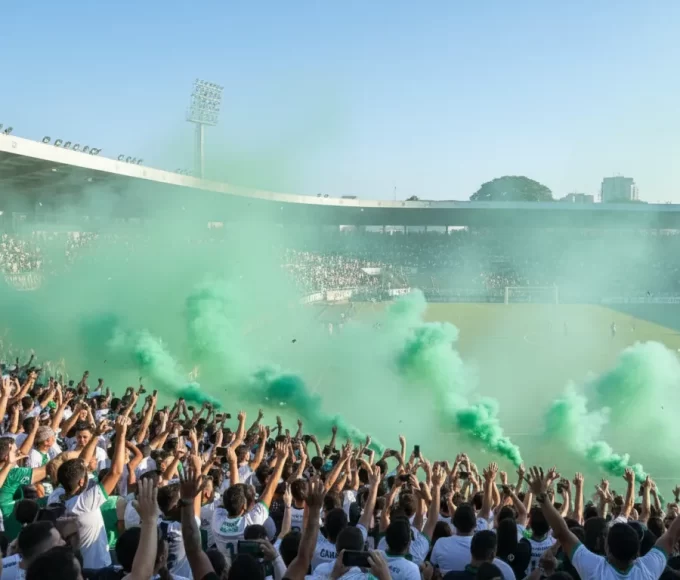 Grande multidão de torcedores com seus Maringá FC ingressos celebrando nas arquibancadas do Estádio Willie Davids, em meio a uma densa e vibrante nuvem de fumaça verde.