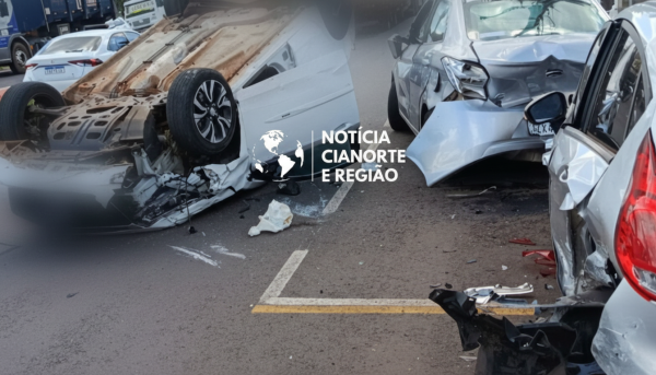 Carro capotado de rodas para cima na Avenida Paraíba após um acidente em Cianorte envolvendo veículos estacionados