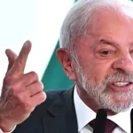 Presidente Lula discursa em púlpito oficial, simbolizando o embate político entre Lula e Bolsonaro
