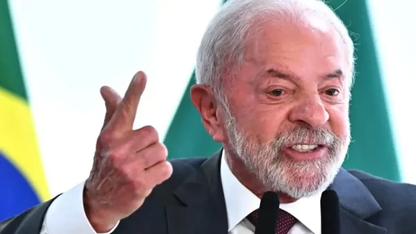 Presidente Lula discursa em púlpito oficial, simbolizando o embate político entre Lula e Bolsonaro