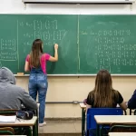 Sala de aula com professora explicando matéria para o PSS da Educação no Paraná.